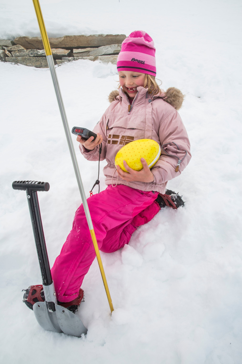 Jente i snø med påskeegg og skredsøker